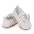 Close-up of white infant walking shoes with cute rabbit ear design and elastic strap - White