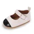 Detailed view of baby girl walking shoe featuring white leather and black glossy cap toe - White