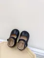 Detailaufnahme schwarzer Baby Mary Janes aus Leder mit dekorativen Blumenknöpfen. - Größe 15 Innenlänge 11.5cm / Schwarz
