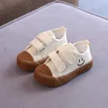 Beigefarbene Kinder-Stoffschuhe mit Smiley und brauner strukturierter Kekssohle. - Khaki