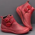 Close-up of red leather ankle boots showing decorative wrap-around straps and sole - 35 / Red
