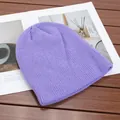 Dettaglio del berretto in maglia a coste viola posizionato su un tavolo di legno scuro. - Alta elasticità / Violetto
