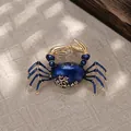 Primo piano di una spilla a forma di granchio vintage in smalto blu con dettagli dorati - Blu