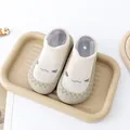 Detailopname van beige babysok-schoenen met een schattige glimlach en rubberen zool. - Beige