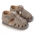 Gros plan de sandales d'été grises pour bébé avec semelles souples et motifs de fleurs - Gris