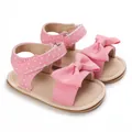 Detailed view of pink polka dot baby sandals featuring a soft sole and bow accent - Pink