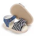 Primo piano dettagliato di sandali estivi per bambina con fiocco vichy e cinturino in denim - 11cm / Stile Fiocco a Quadretti Bianco e Nero / Quadri bianchi e neri
