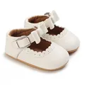 Close-up detail of white baby princess walking shoes with bow and scalloped trim - White
