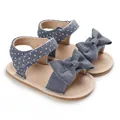 Detailed view of baby girl denim polka dot sandals featuring a large bow and soft sole design - Dark Blue