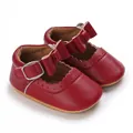 Close-up of red baby Mary Jane shoes with soft sole and cute bow detail for infants. - Red
