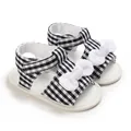Close-up of baby sandals featuring black and white checkered pattern with white bows - 11cm / Black