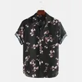 Front view detail of a men's black short-sleeve shirt with elegant pink floral patterns. - S / Tops / Black