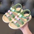 Close-up of stylish green girls' sandals with colorful macaron bows and soft flexible sole. - 24 / Green