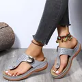Close-up of grey wedge thong sandals with hollow patterns and buckle detail - Gray