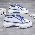 Vista dettagliata delle sneakers da uomo bianche e blu con spesse suole a cuscino d'aria - Bianco Blu