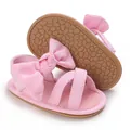 Close-up of pink baby girl sandals with large bow and soft rubber sole - Pink