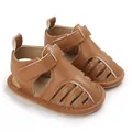 Détail de sandales brunes pour bébé avec design creux respirant et semelles antidérapantes. - Marron