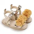 Détail de sandales d'été pour bébé fille ornées de fleurs jaunes et d'un fini doré. - Or champagne