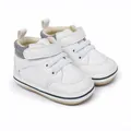 Detailed view of white faux leather baby pre-walker shoes featuring soft soles and velcro. - 11cm / White