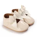 Detailansicht der beigefarbenen Babyschuhe aus Lackleder mit eleganten großen Schleifen - Aprikose