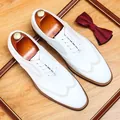Classic white leather men's dress shoes with elegant British brogue style patterns - White