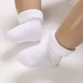 Detailed macro view showing the breathable mesh texture of pure white newborn baby socks. - Infant Size / Cuffed Style / White