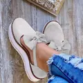 Détail en gros plan de sandales à plateforme en daim pour femmes avec un grand nœud - Beige