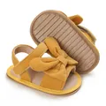 Macro detail of baby girl yellow corduroy bow sandals showing flexible anti-slip rubber sole - Yellow