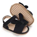 Close-up of black corduroy baby girl sandals with a large bow and non-slip sole - Black