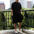 Outdoor street style view of men's black ribbed short sleeve and shorts set - Black