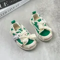 Green and white canvas baby walking shoes with soft soles and decorative cream bow laces - Size 15 Inner Length 12.5cm / Green