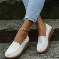 Vue détaillée de mocassins en cuir blanc avec bout rond cousu main sur des marches - Blanc
