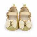 Vue détaillée des chaussures dorées à paillettes pour bébé avec des nœuds crème élégants - Or