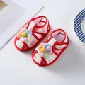 Close-up detail of infant girl summer walking shoes featuring colorful 3D plush flowers - Red
