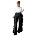 Vista detallada de los pantalones de pierna ancha con volantes laterales y talle alto - Negro