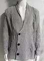 Detailansicht eines grauen Zopfstrick-Cardigans mit Distressed-Effekt und Knöpfen. - M / Oberteile / Grau