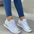 Detailed view of white sneakers with gold metallic accents and quilted texture. - 35 / White