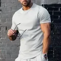 T-shirt bianca da uomo minimalista a girocollo presentata su un modello contro un muro - Bianco