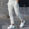 Close-up detail of white men's slim-fit joggers featuring stylish front seams and drawstring - White