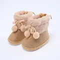 Detailansicht weicher Baby-Winterstiefel mit flauschigem Kunstpelzbesatz und niedlichen Bommeln - Kaffeebraun