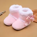 Dettaglio di scarpine rosa per neonati con fodera in peluche e fiocco a quadretti - Rosa