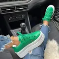 Detaillierte Seitenansicht trendiger grüner Leder-Plateau-Sneaker mit weißen dicken Sohlen im Auto - Grün