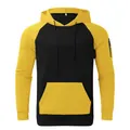 Detailed close-up of a men's yellow and black raglan hoodie with a functional sleeve zipper - Yellow Black Patchwork