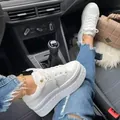 Close-up of white platform sneakers with thick soles and lace-up design in car setting - 35 / White
