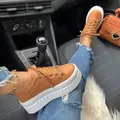 Close-up of stylish brown lace-up platform sneakers with thick white soles in a car setting. - 35 / Khaki