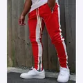 Close-up detail of red and white color block joggers featuring functional ankle zippers - M / Bottoms / Red & White