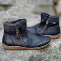 Close-up detail of women's black leather ankle boots with plaid collar and side zipper - 35 / Black