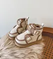 Detailed macro view of cream toddler snow boots showing plush lining and buckle design - Beige