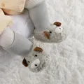 Primer plano de adorables botas de peluche para bebé con forma de oveja en alfombra - Gris