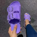 Detailed view of purple canvas slide sandals featuring frayed edges and double metal buckles. - Purple